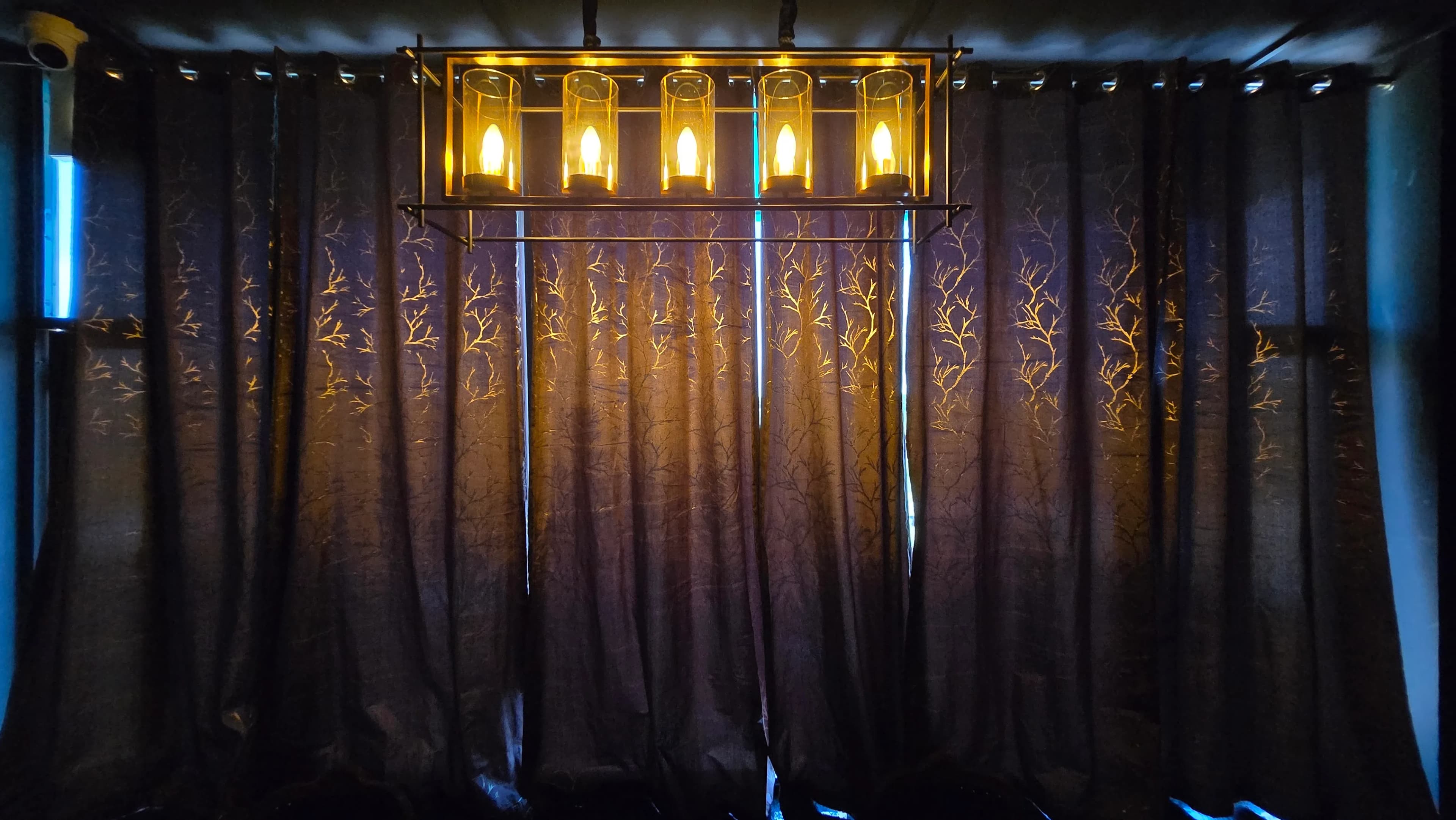 Golden chandelier glowing against patterned drapes